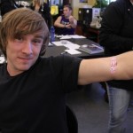 A genetics students shows off his band-aid after having blood drawn for a DNA experiment.
