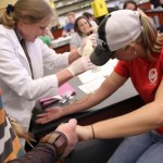 A genetics students gets ready for her blood to be drawn by Dr. Bernadette Fincher.
