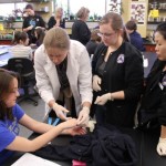 Chair of the Department of Nursing Dr. Bernadette Fincher assists nursing students in drawing blood from a genetics student.