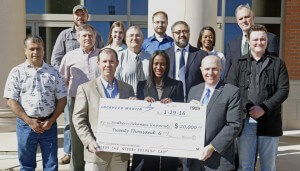 Scott James, Lockheed Martin manager of production engineering, front row from left, Charley Jackson, Lockheed Martin HR business partner, give a $20,000 check to SAU President Dr. Trey Berry for SAU Engineering with representatives from SAU's growing program looking at in front of the Science Center.